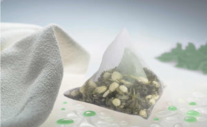 Teaposy green tea peppermint jasmine posy flower tea bath, next to a bath towel